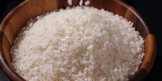 缓慢下落的日本大米。木碗里的生米粒