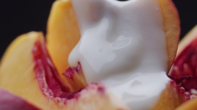 酸奶倒在新鲜的桃子片上。极端特写镜头