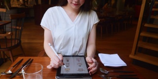 年轻女插画家在舒适的餐厅画画
