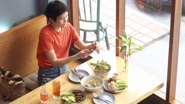 一名女博主在餐馆拍摄食物