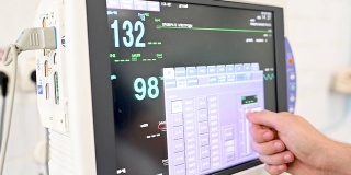 在重症监护病房，医生更改显示器屏幕上的数据