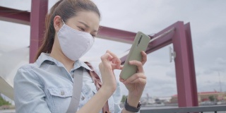 亚洲成年女性在泰国当地旅游时使用智能手机与家人聊天。有魅力的女性在当地旅游时用手机给她的社交媒体朋友发短信。独行侠的概念。
