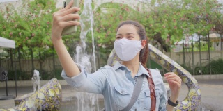 亚洲成年女子在泰国当地旅游时自拍。有魅力的女性在当地旅游时，用智能手机给社交媒体上的朋友打电话。独行侠的概念。