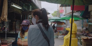 亚洲成年妇女在当地旅游的地方散步和购物。有吸引力的女性寻找街头食品，而旅行在当地地区。独行侠的概念。