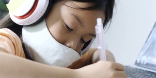亚洲女孩在COVID-19期间在家学习电子学习，生活方式概念。