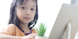 亚洲女孩在COVID-19期间在家学习电子学习，生活方式概念。