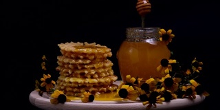 蜂蜜倒在华夫饼上。美味健康的早餐配比利时华夫饼