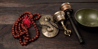 在棕色的木桌上放着一个带拍子的西藏唱歌铜碗，是用来冥想和替代医学的物品