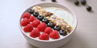 自制酸奶碗与覆盆子，蓝莓和格兰诺拉麦片-健康的食品风格