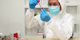医生、科学家、研究员手戴蓝色手套，手持流感、麻疹、冠状病毒、covid-19疫苗疾病，准备进行人体临床试验接种疫苗。