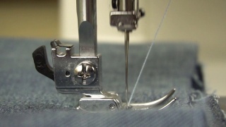 在缝纫机上缝制时脚和针的慢动作。视频素材模板下载
