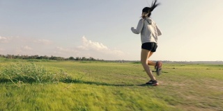 运动员跑步亚洲女运动员在日落日出。