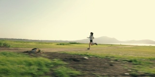 运动员跑步的剪影，一个女跑步者在日落日出。