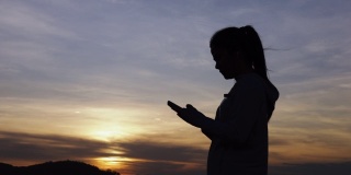 肖像剪影运动亚洲女人使用智能手机聊天。