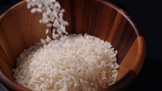 缓慢下落的日本大米。木碗里的生米粒视频素材模板下载