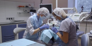 总体计划两名女牙医执行病人的牙齿手术，现代牙科，医疗设备，计算机