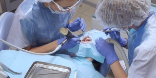 密切牙科医生穿戴防护服和手套协助病人进行牙科手术，并配合专家团队进行医疗传染病卫生慢动作