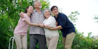 亚洲家庭快乐的支持老人在公园。