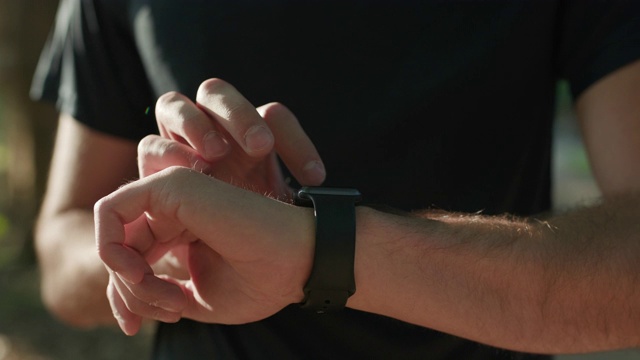 男人的手触摸着智能手表。户外男士手上的智能手表