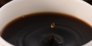 以烘培咖啡豆为背景的杯子里的咖啡