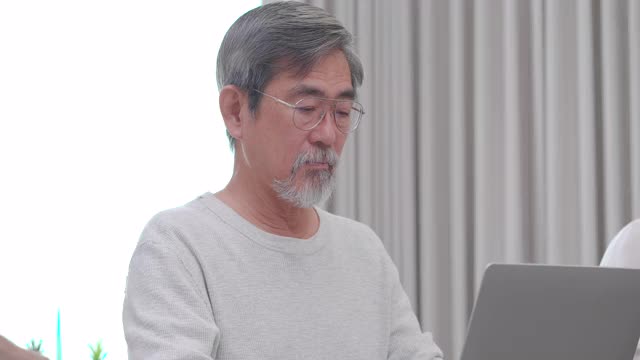 一群年龄在60-70岁之间的亚洲高年级学生，他们参加初级计算机培训课程，作为他们老年教育的一部分。成人语言学习概念。