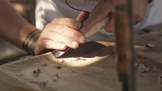 木雕师用凿子加工胡桃木板。工匠在做一个茶盘视频素材模板下载