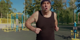 做运动的老人。老人在公园里跑步。健康的生活方式和锻炼的概念。
