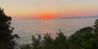 日落在地中海地平线上的岩石，松树。
