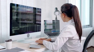 4k视频片段的年轻亚洲女性程序员阅读和工作在电脑上编码开发网站设计和开发技术视频素材模板下载