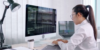 4k视频片段的年轻亚洲女性程序员阅读和工作在电脑上编码开发网站设计和开发技术