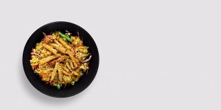 一套不同的彩色炒锅上的黑色盘子动画上的白色和灰色背景。中式烹饪用肉、蔬菜和面条