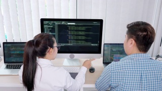两个专业的IT程序员讨论和工作在电脑上编码开发网站设计和开发技术的4k视频片段视频素材模板下载