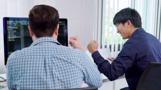 两个专业的IT程序员讨论和工作在电脑上编码开发网站设计和开发技术的4k视频片段视频素材模板下载