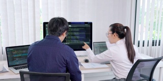 两个专业的IT程序员讨论和工作在电脑上编码开发网站设计和开发技术的4k视频片段