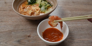 煮海鲜sukiyaki在汤与酱用筷子挑选