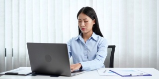 一段女商人在办公室用笔记本电脑工作时看起来很焦虑的4k视频