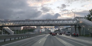 俄罗斯。莫斯科。18.09.2020透过汽车的挡风玻璃，在一个六车道高速公路上，有立交桥和行人天桥，在城市中，汽车沿着这条公路行驶。