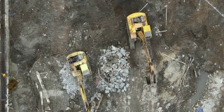 地面上建筑工地的工人和挖掘机的无人机鸟瞰图