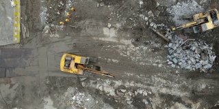 地面上建筑工地的工人和挖掘机的无人机鸟瞰图