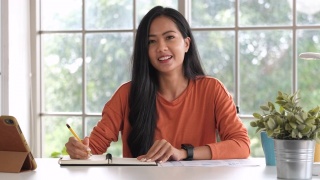 亚洲妇女在家里用笔记本电脑进行视频会议。新常态办公生活理念视频素材模板下载