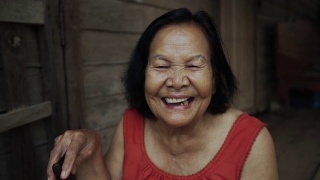 慢动作的泰国老妇人圆领无袖领在老木屋里笑视频素材模板下载