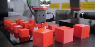 在机器人展上挑选并放置移动红色玩具块的机械手
