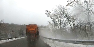 后视镜扫雪机服务卡车和撒盐砂砾路面，以防止结冰在暴风雪的冬天的日子，缓慢的动作