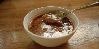 餐馆里一碗热腾腾的格鲁吉亚烤肉汤。他用勺子把羊肉块搅拌在汤里。