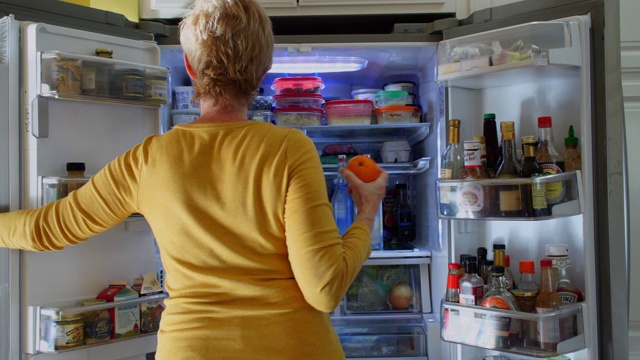 在冰箱里找零食的女人