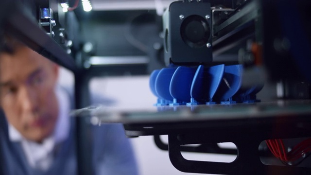 3D打印机构建螺旋桨模型和亚洲男性工程师俯瞰进展