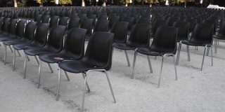 为户外展览准备的一排排空的黑色塑料椅子