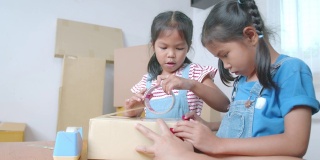 两个小女孩帮助家长用胶带把产品包装好，然后用快乐的心情将产品送到网上顾客手中。