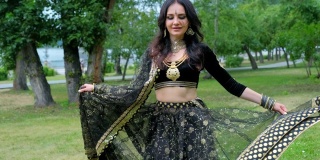一个女性模特的肖像在民族印度服装与珠宝和传统的化妆。穿着印度服装跳肚皮舞的女人。年轻漂亮的女人穿着民族服装跳部落舞