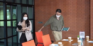 一群多种族的商务人士开会时戴上口罩以防止感染